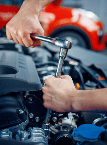 Mechanic working on a car engine with a wrench